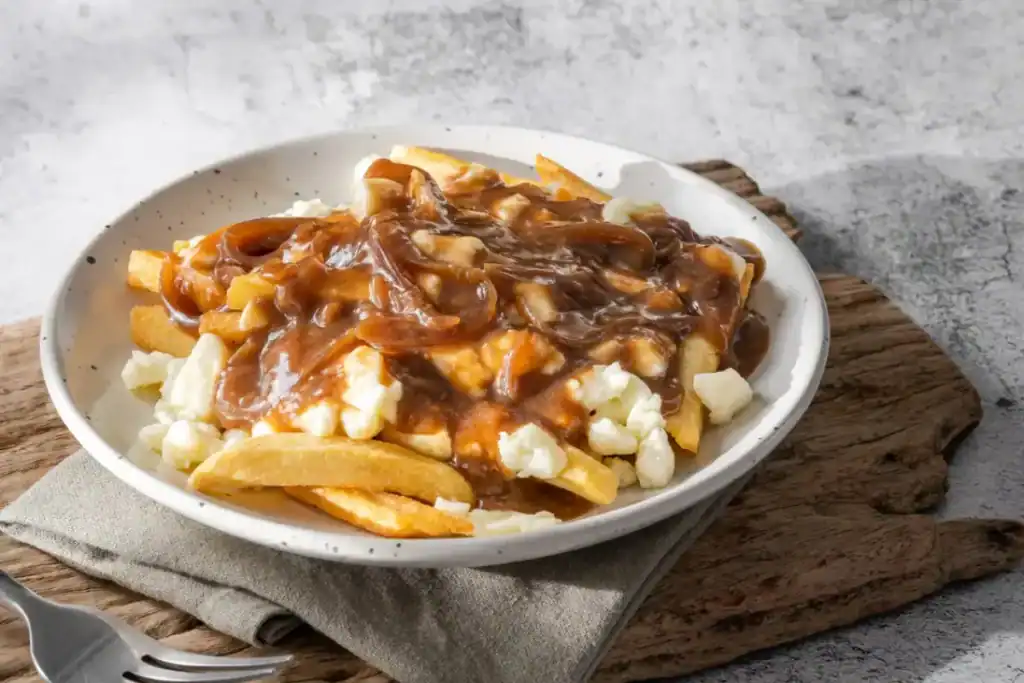 Poutine maison dans une assiette avec sa sauce brune et du Fromage
