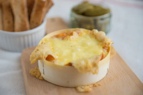 camembert rôti au four coulant dans sa boîte en bois