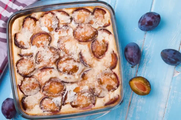clafoutis aux prunes doré dans son plat avec des quetsches et du sucre glace clafoutis aux prunes doré dans son plat avec des quetsches et du sucre glace