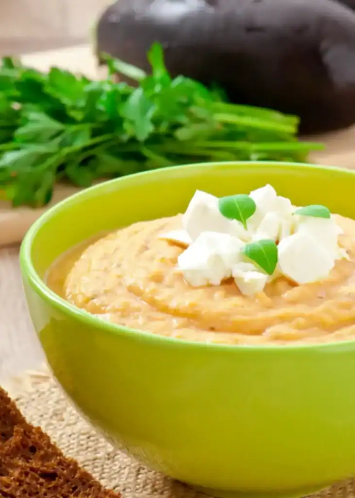 Velouté d'aubergines rôties, servi dans un bol avec un morceau de pain